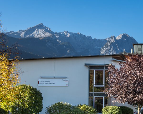 Ein Gebäude und dahinter die Berge von Garmisch Partenkirchen | © Ferdinand Brunnenmayer